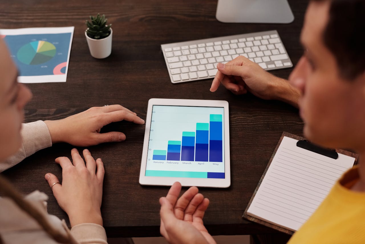 Mastering the First Impression: Your intriguing post title goes here Team members discussing digital graphs on a tablet in a modern office setting.