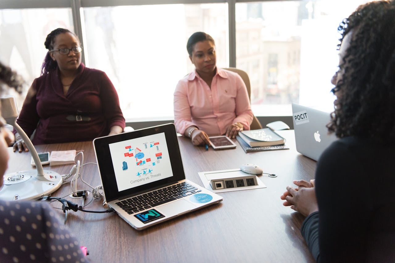 The Art of Drawing Readers In: Your attractive post title goes here Business meeting with diverse team using laptops and tablets in a modern office setting.